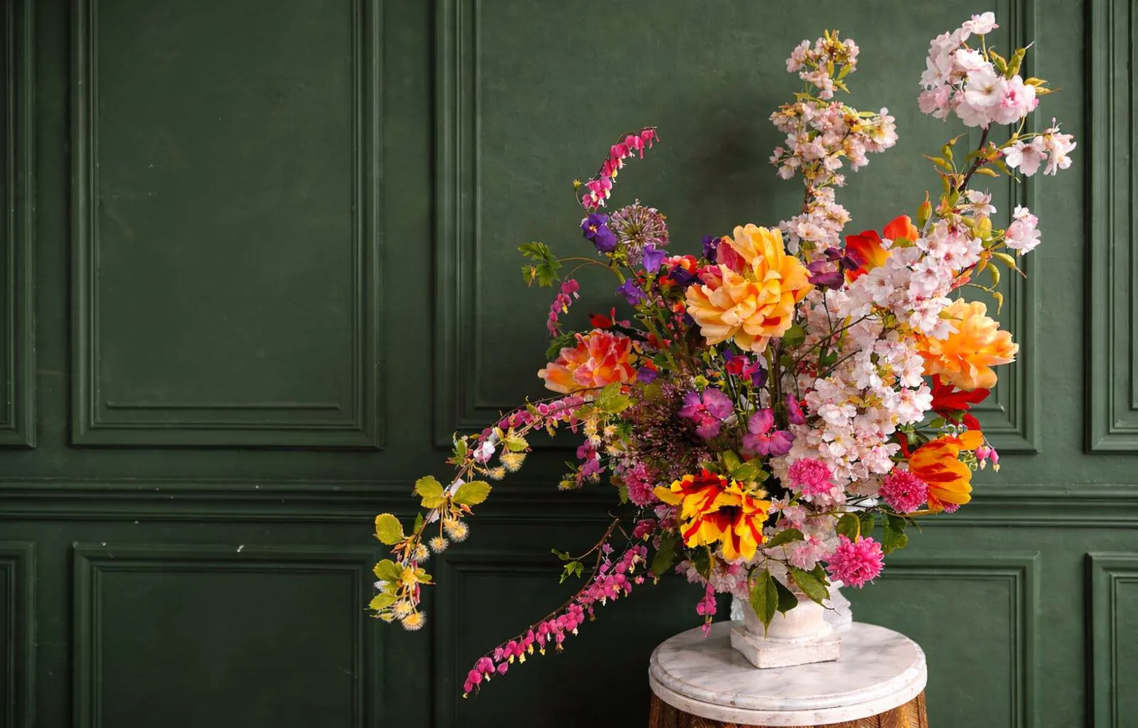 Zeitgenössische Blumenskulptur von HOUSER vor einem gedämpften grünen Hintergrund.